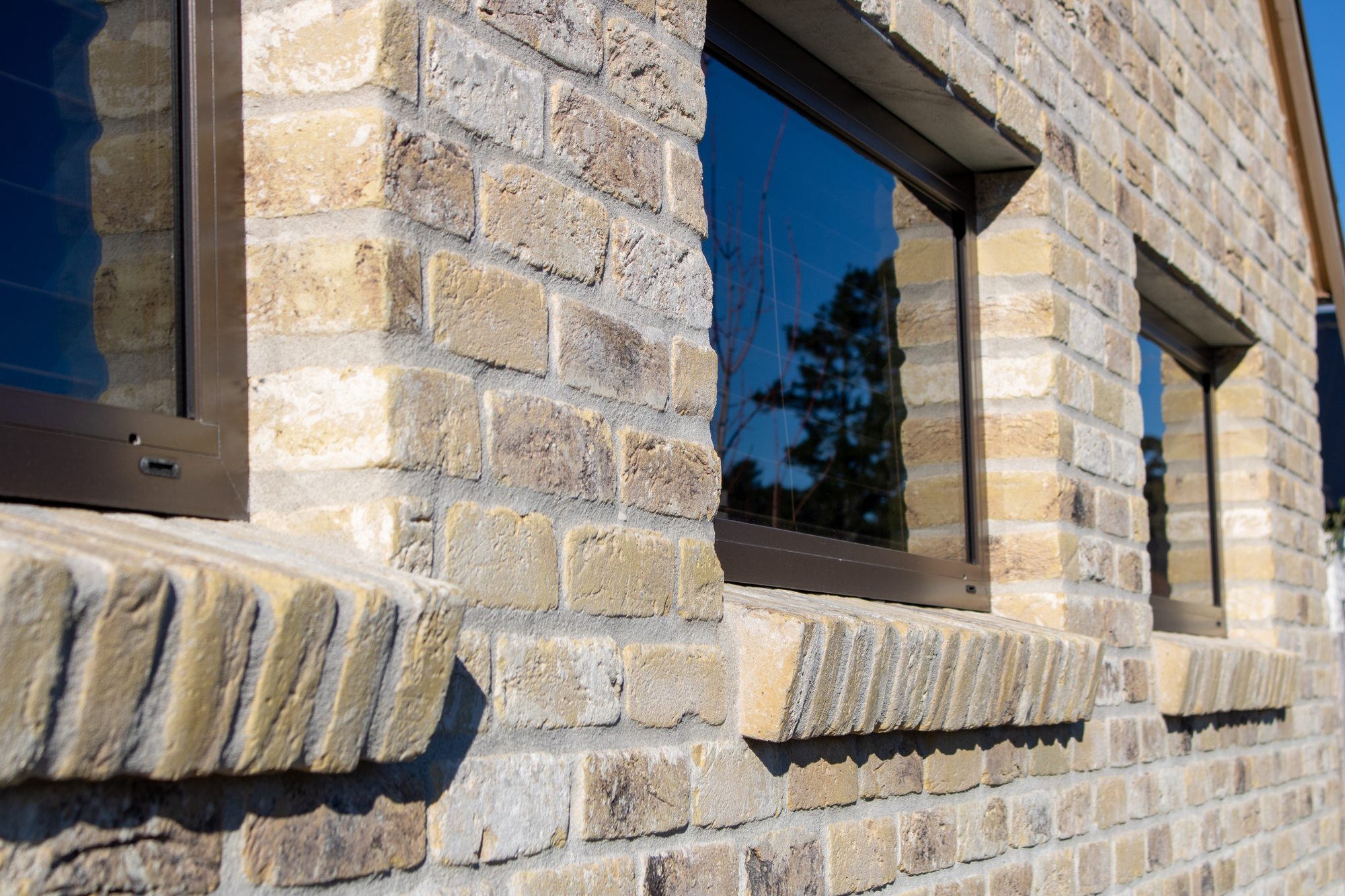 Imported Belgian brick detail with stone sill and mid bronze joinery