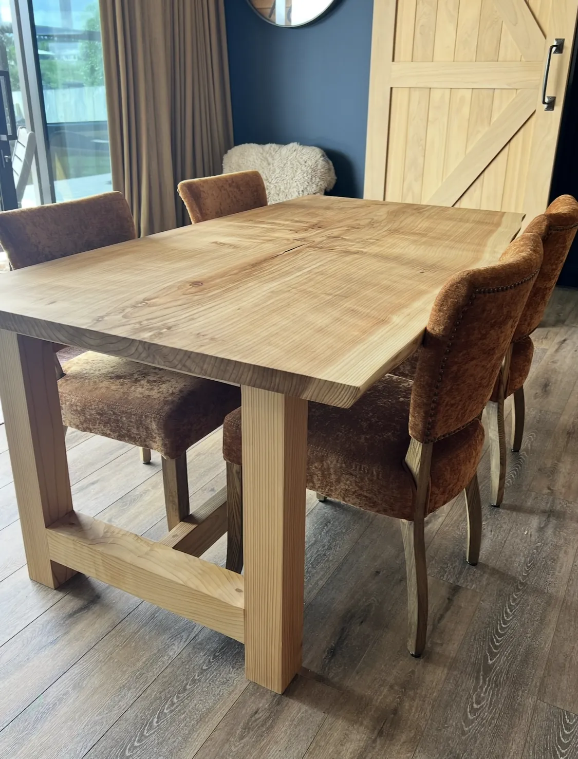 Timber dining table with barn door and navy wall